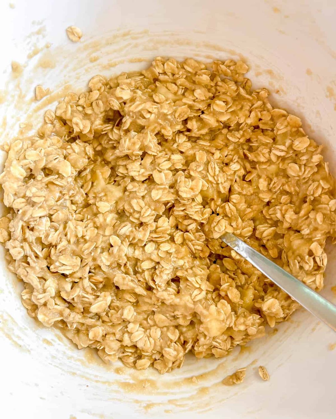 Wet and dry ingredients for chocolate chip oat banana cookies in a bowl.