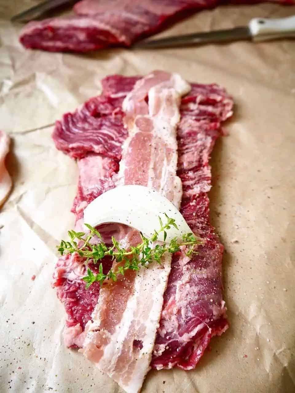 Steak with bacon and onion on top.