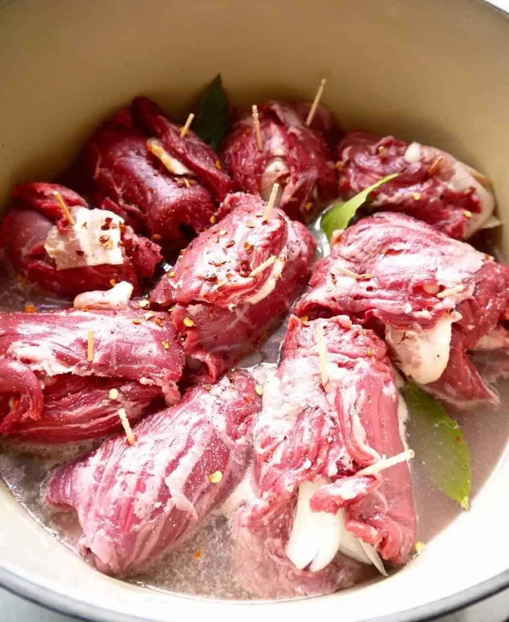 Beef roll ups with bacon and onion while cooking.