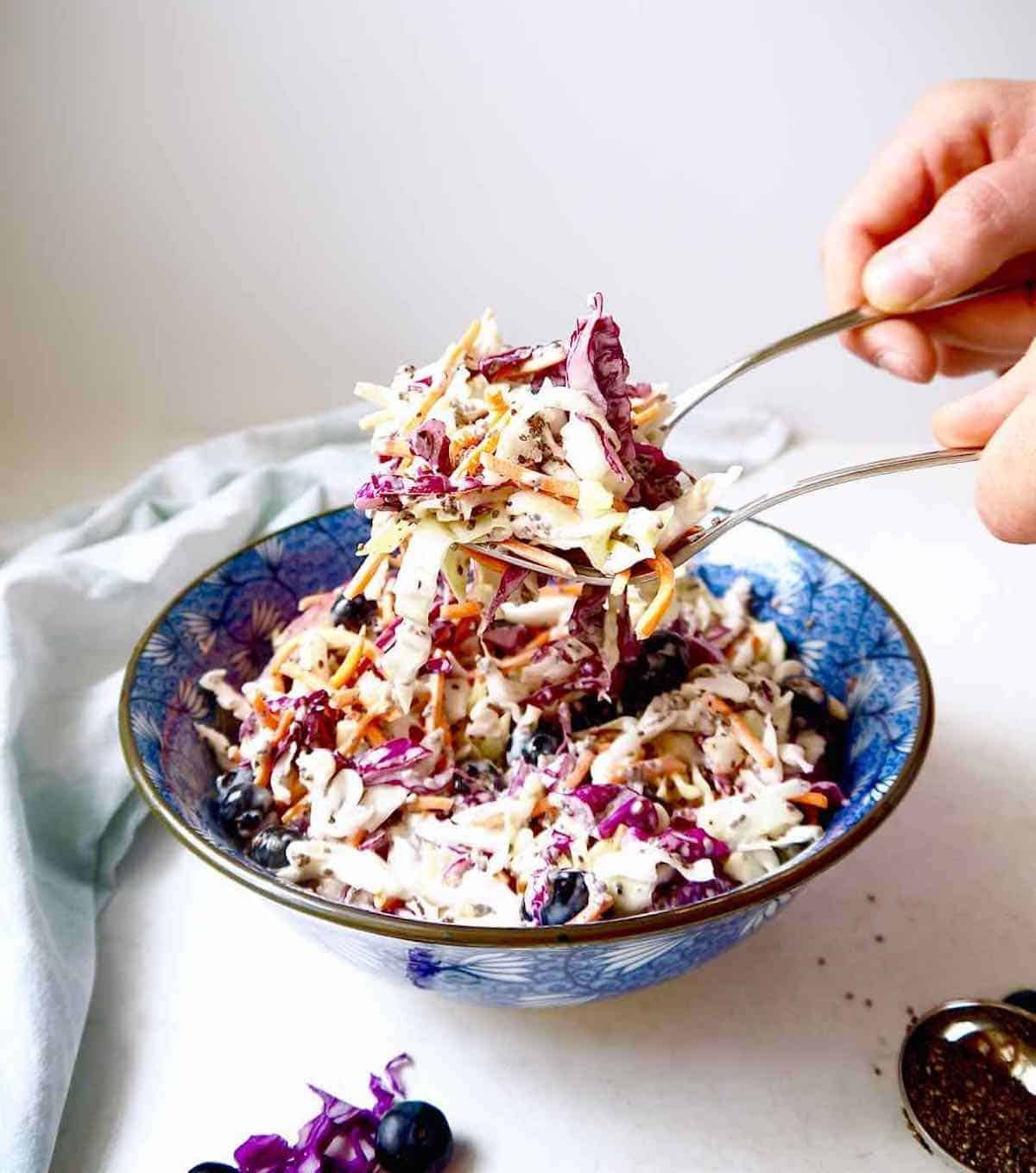 Light coleslaw recipe being served with silverware.