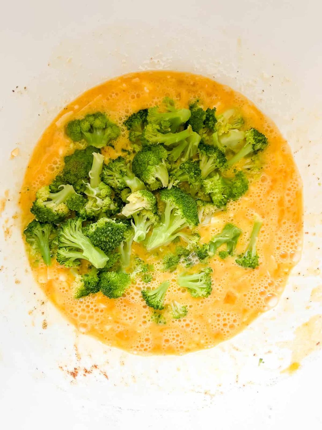 Broccoli added to egg muffin mixture.