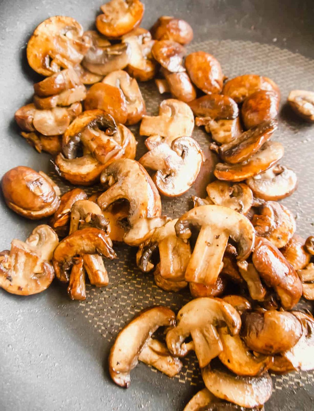 Browned mushrooms in frying pan.