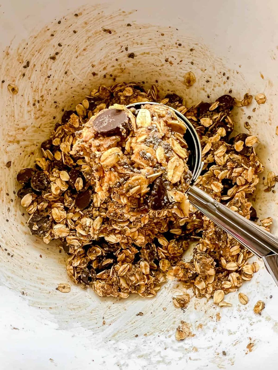 Using a cookie scoop to roll out the energy balls.