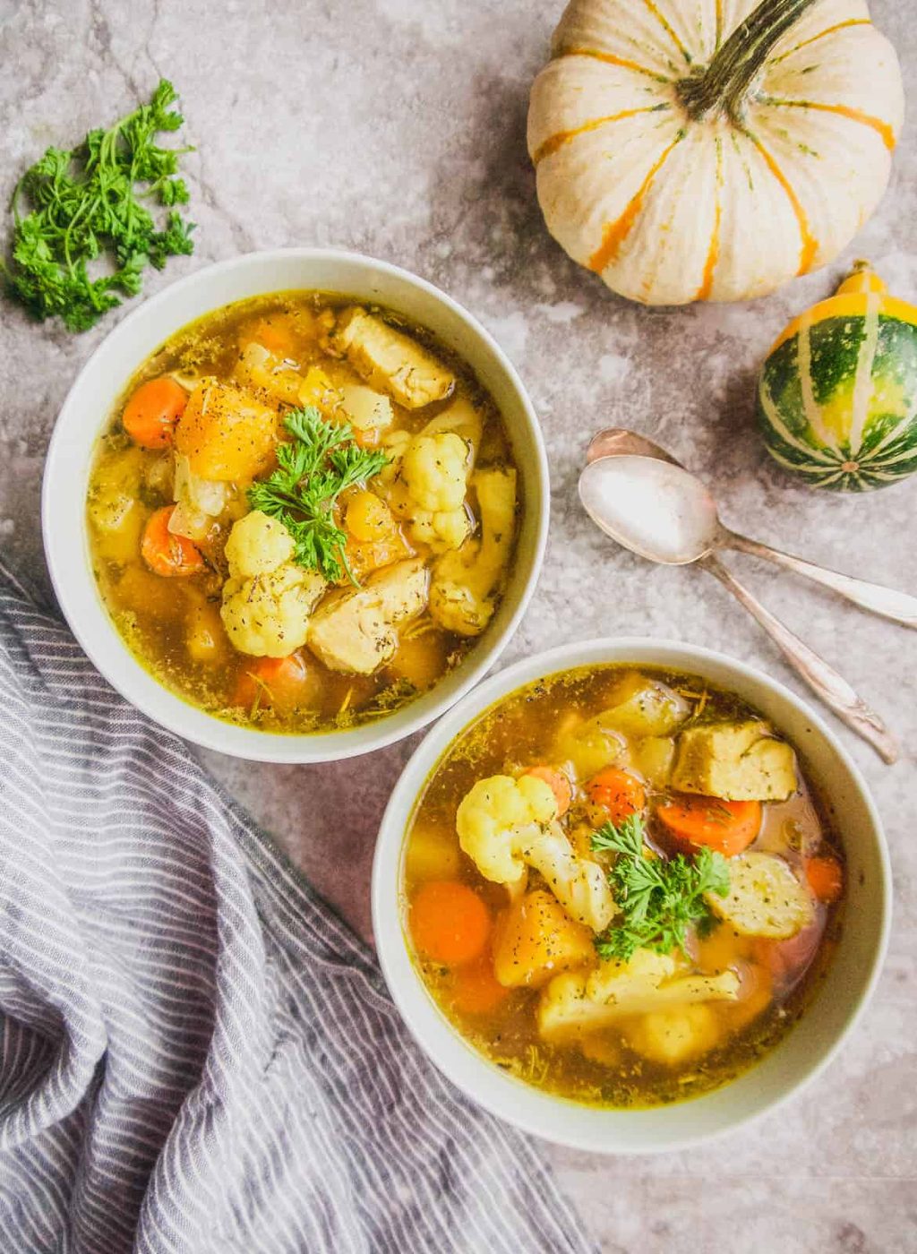 Two bowls of whole30 chicken soup on a table.