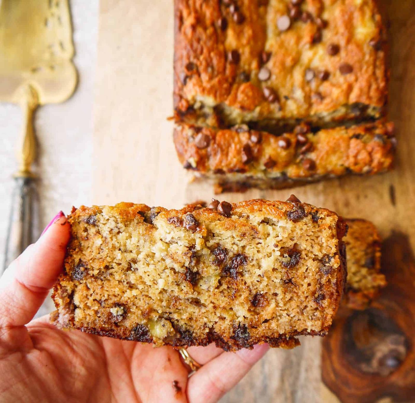 A slice of gluten free chocolate chip banana bread in someone's hands.