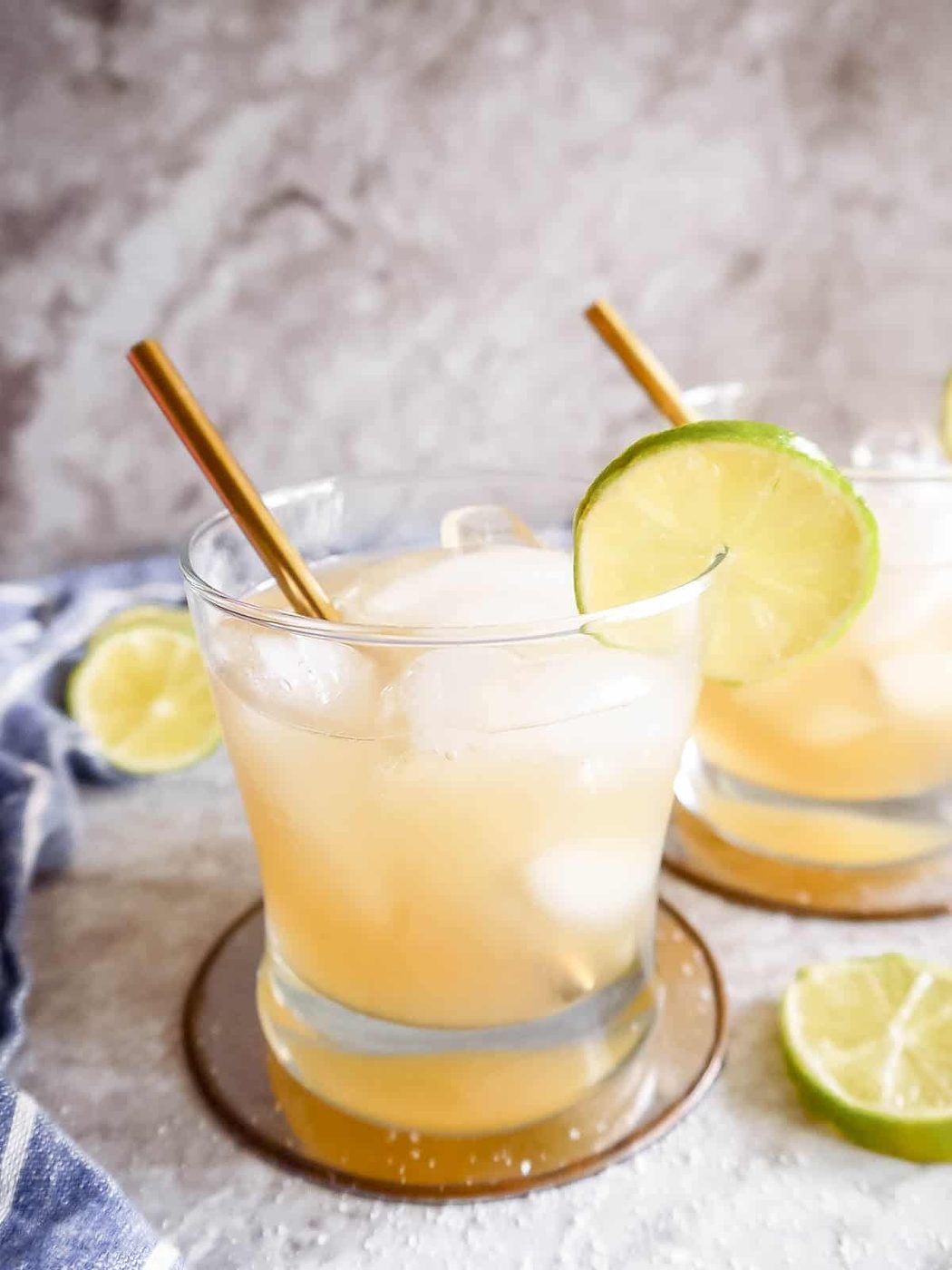 Two glasses of Cointreau Margaritas with limes on the rim.