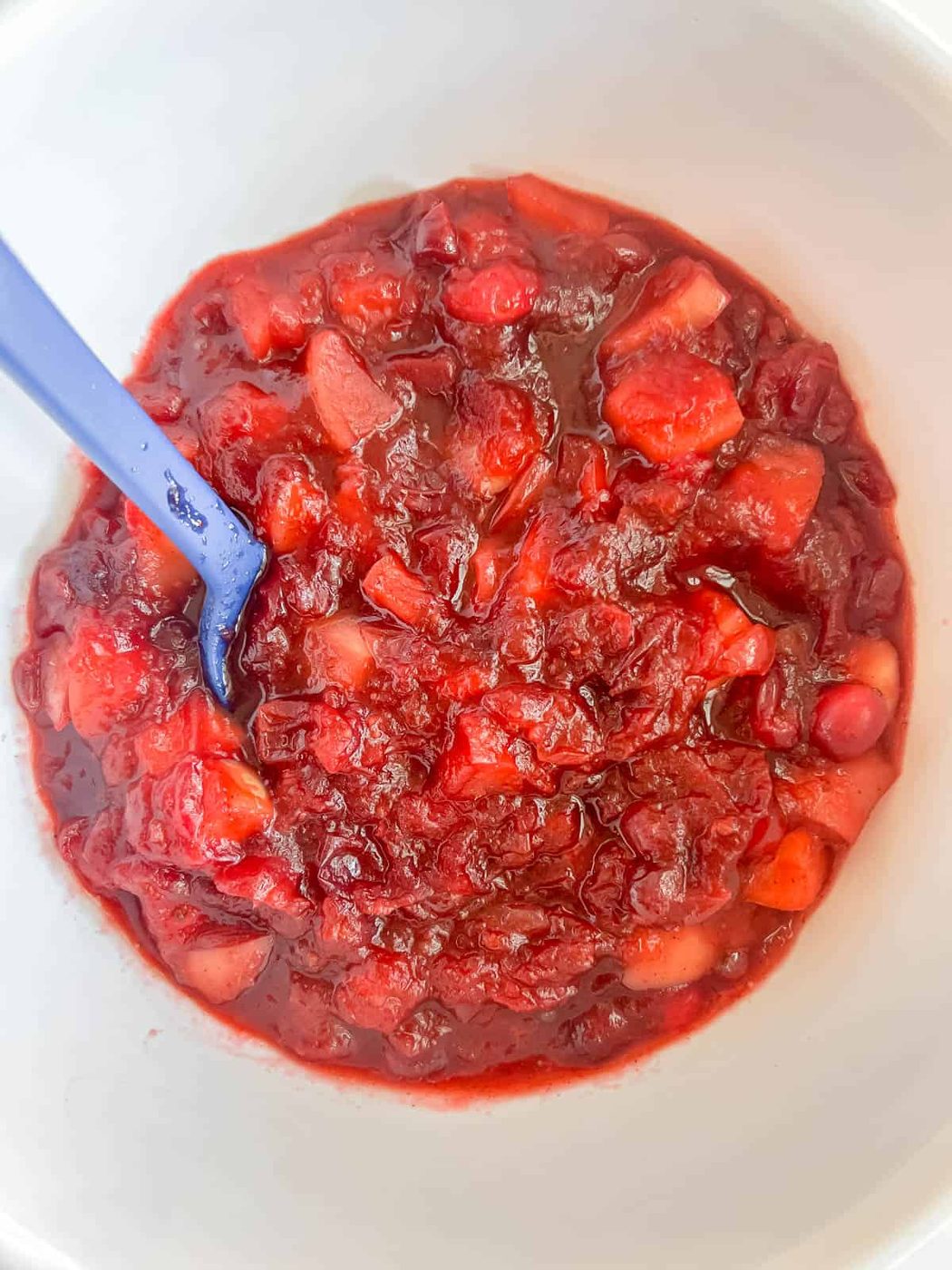 Cranberry sauce with apples cooling in a bowl.
