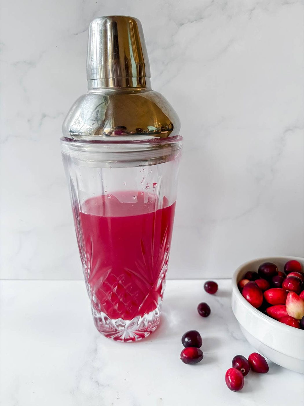 Cranberry margarita ingredients in a cocktail shaker.