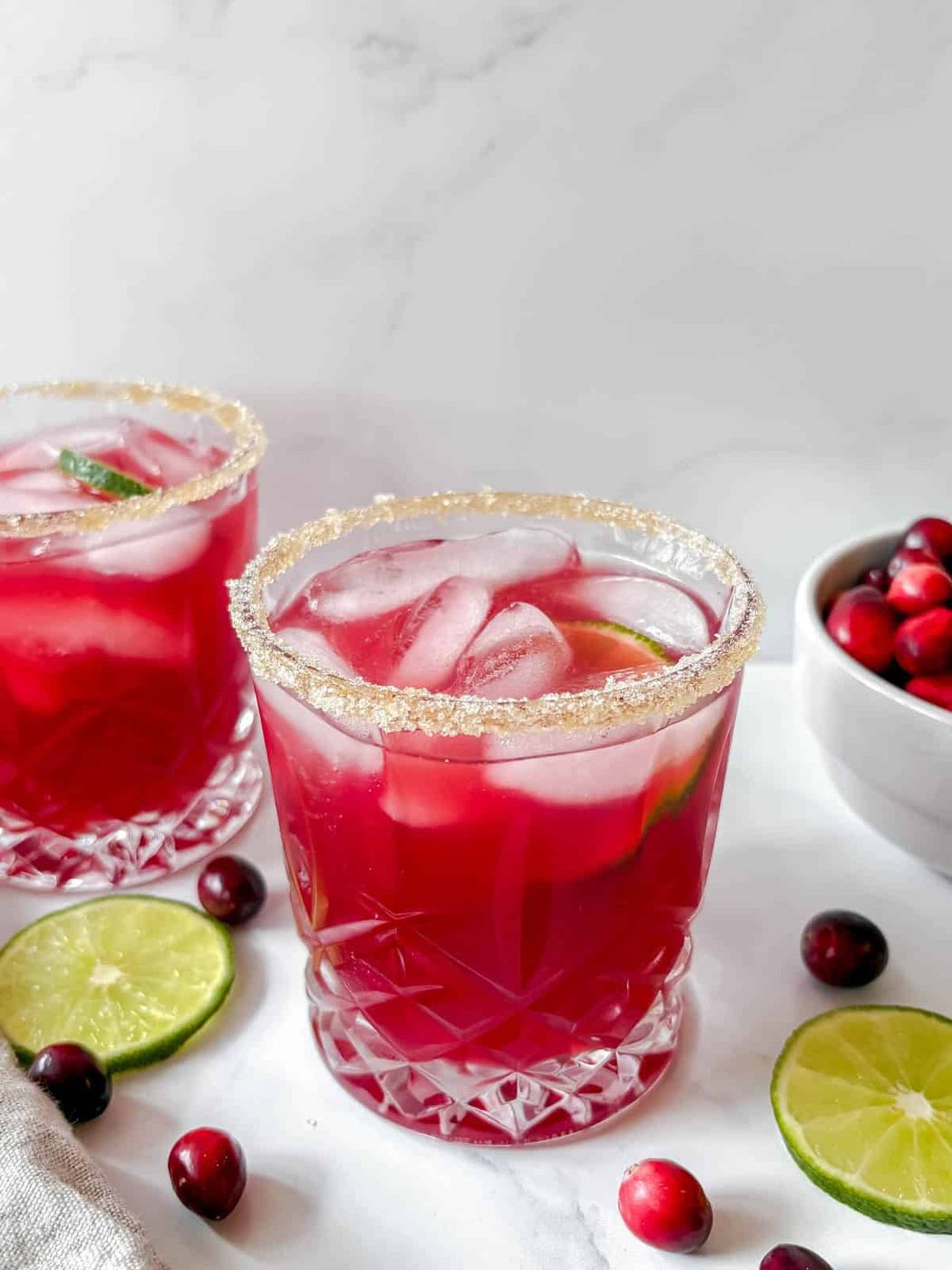 Cranberry margarita with fresh cranberries around it.