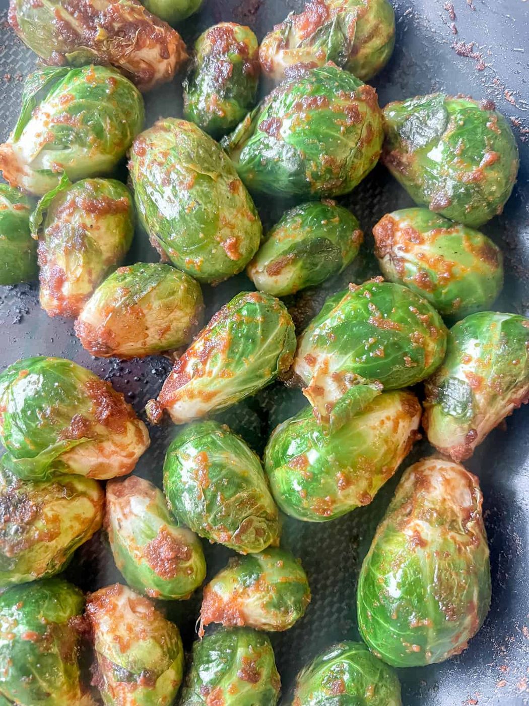 Brussels sprouts in a pan starting to cook.