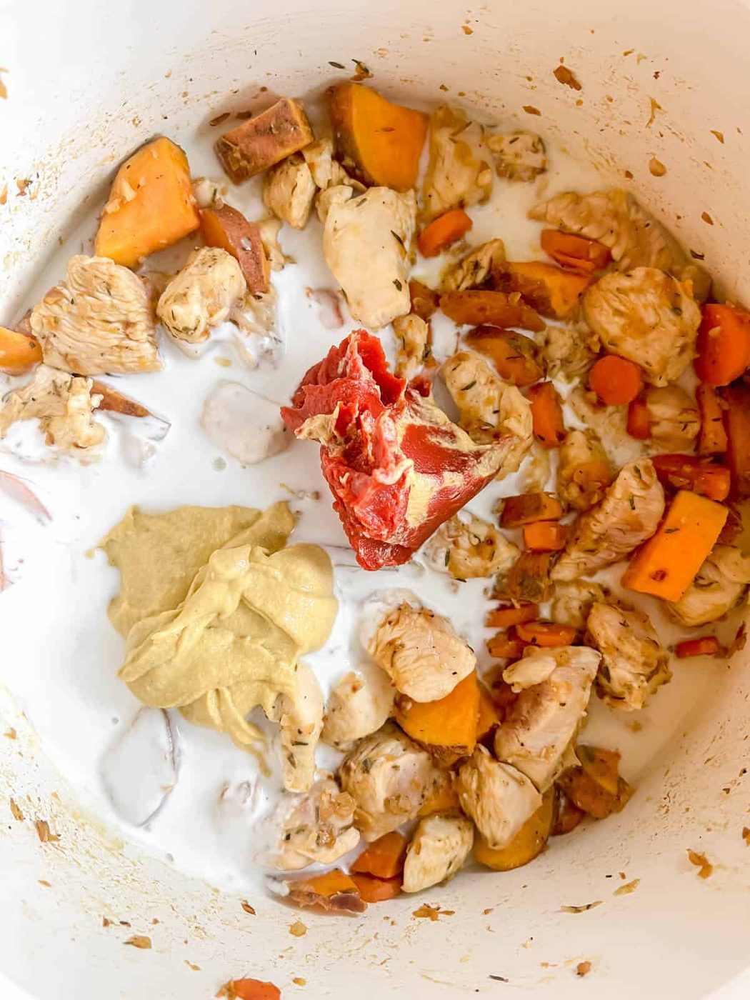 Coconut cream, mustard and tomato paste added to the pan.