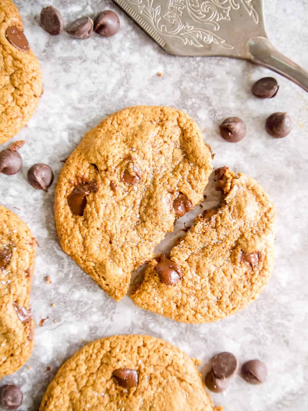 Crispy paleo chocolate chip cookie cut in half.