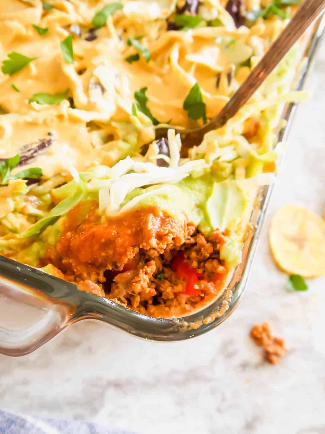 Dairy free 7 layer dip with a spoon scooping some out.