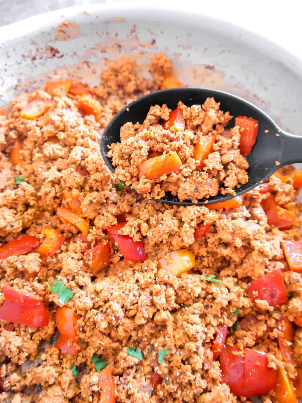 Ground turkey and bell peppers cooked in a pan.