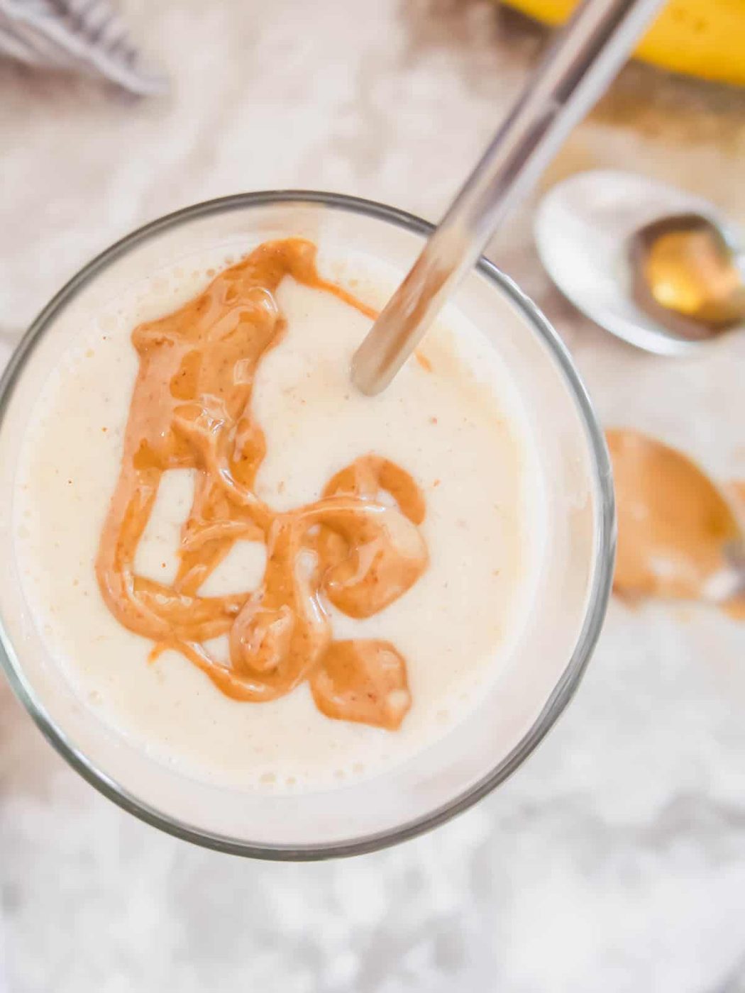 Banana smoothie with yogurt with almond butter drizzled on top.