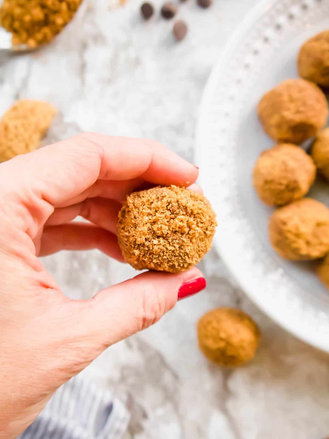 A mousse ball freshly rolled in crushed cookies.