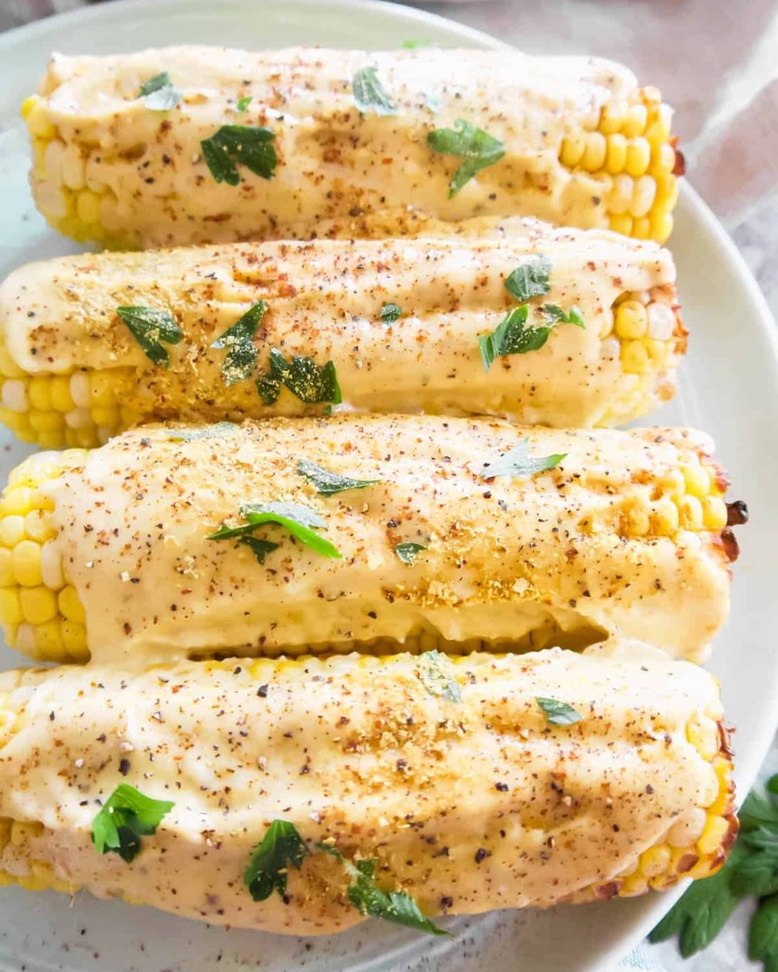 Vegan Mexican street corn on a plate with nutritional yeast sprinkled on top.