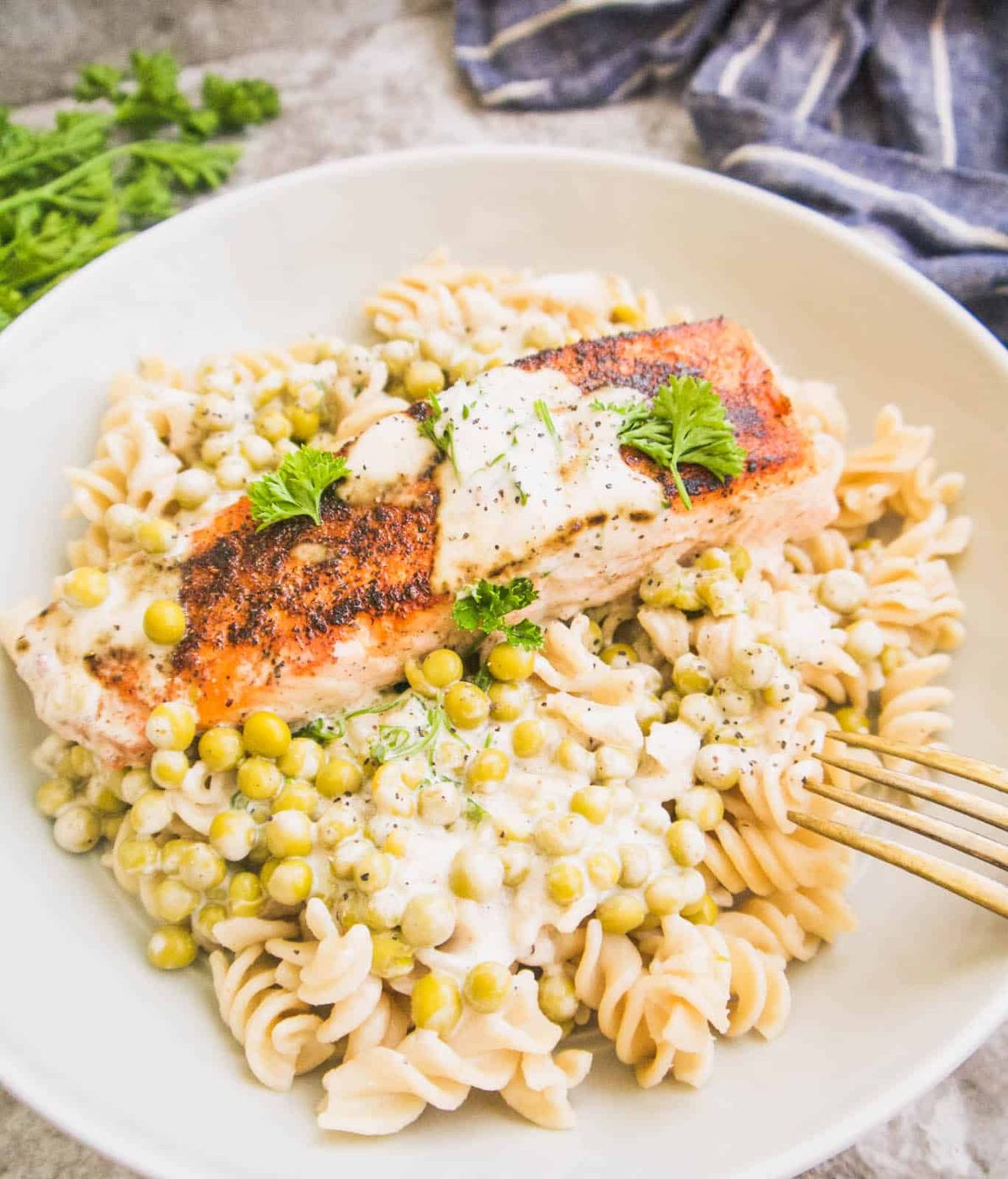 Paleo salmon recipe in bowl with peas in cream sauce.