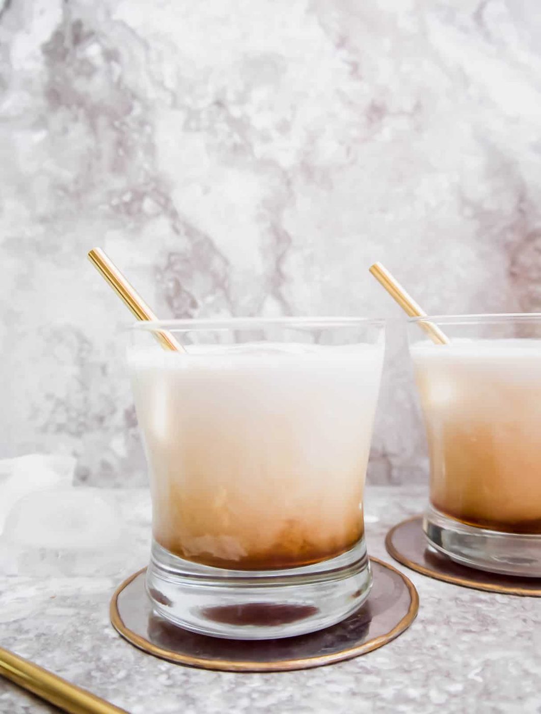 Side angle of two cups of white russian.