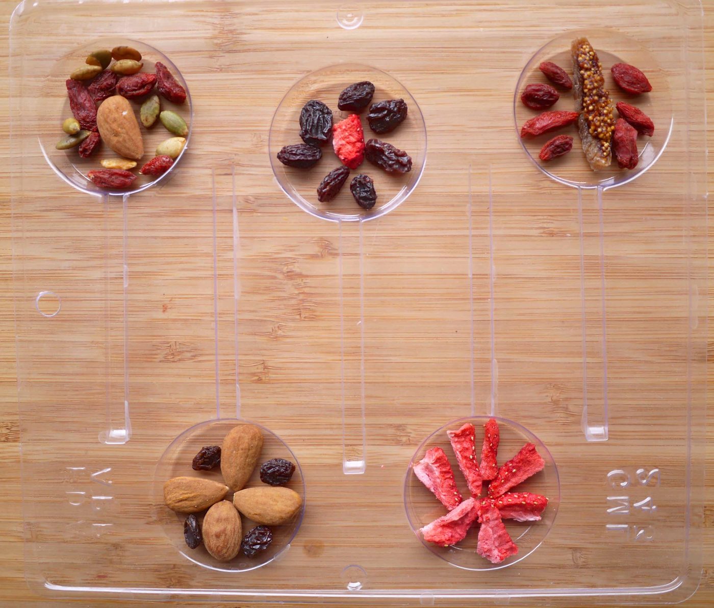 Adding the dried fruit and nuts to lollipop molds.