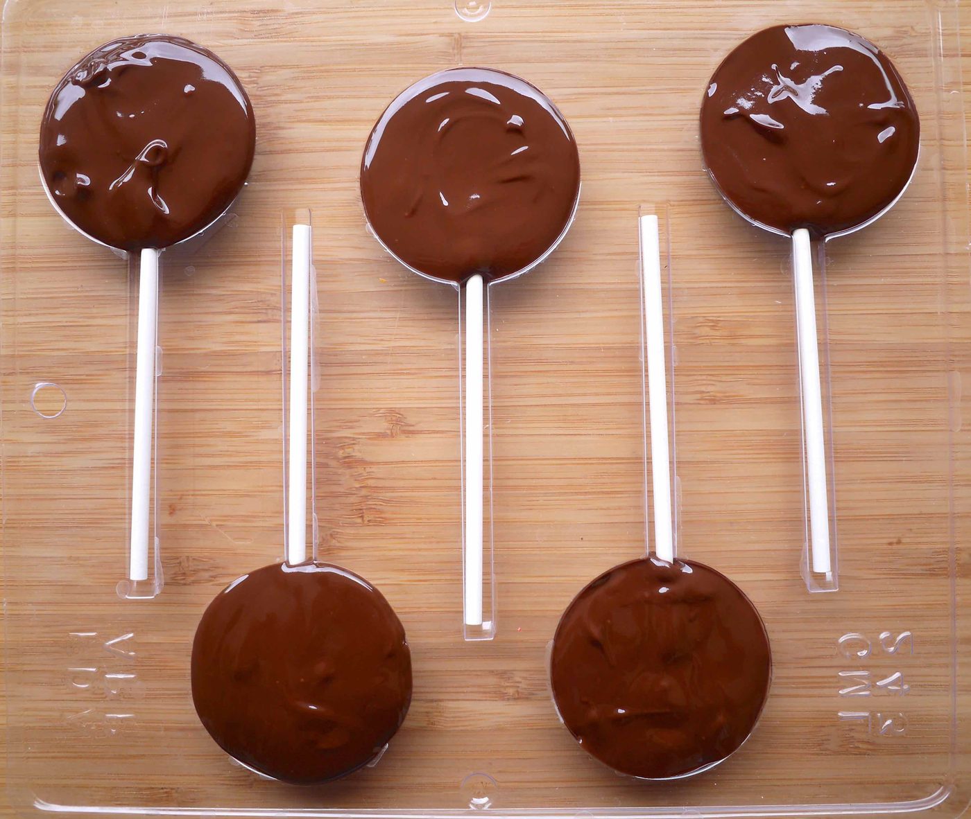 The melted chocolate on the lollipop molds.