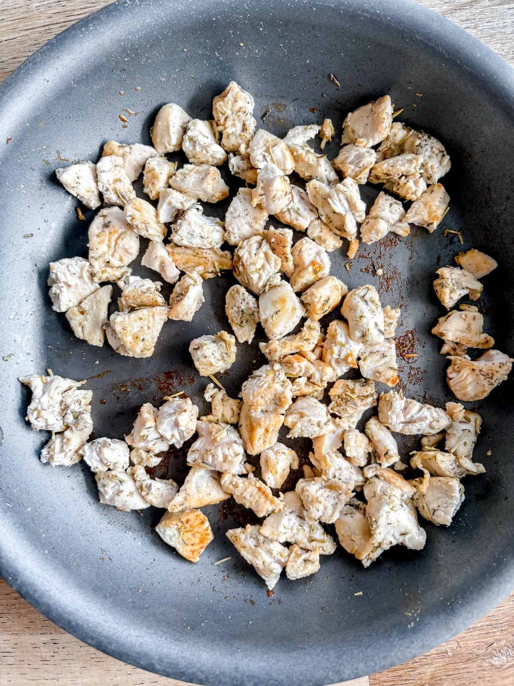 Bite sized chicken cooked in pan.
