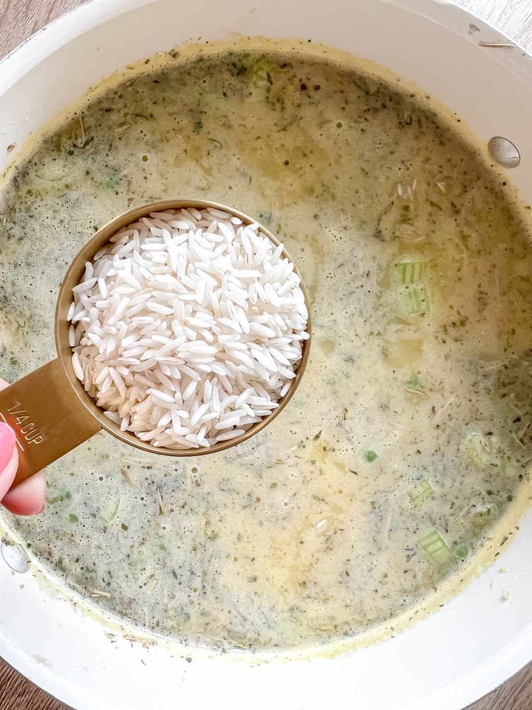 Adding the rice to the soup.