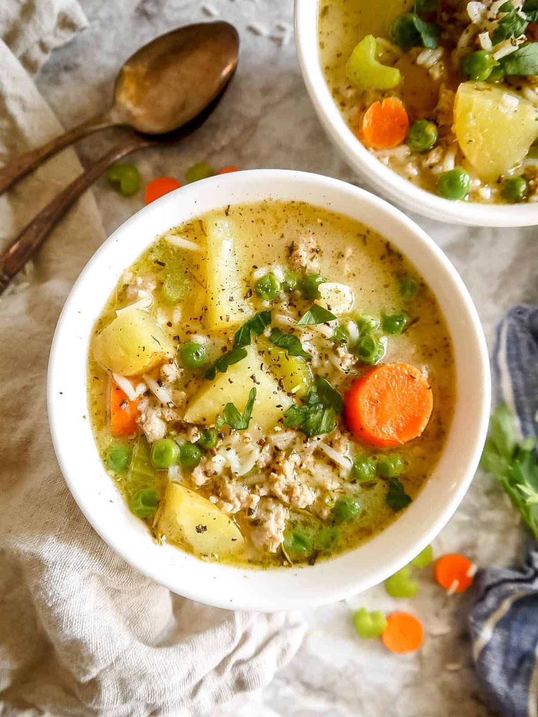 Creamy turkey rice soup in a two bowls with spices on top.