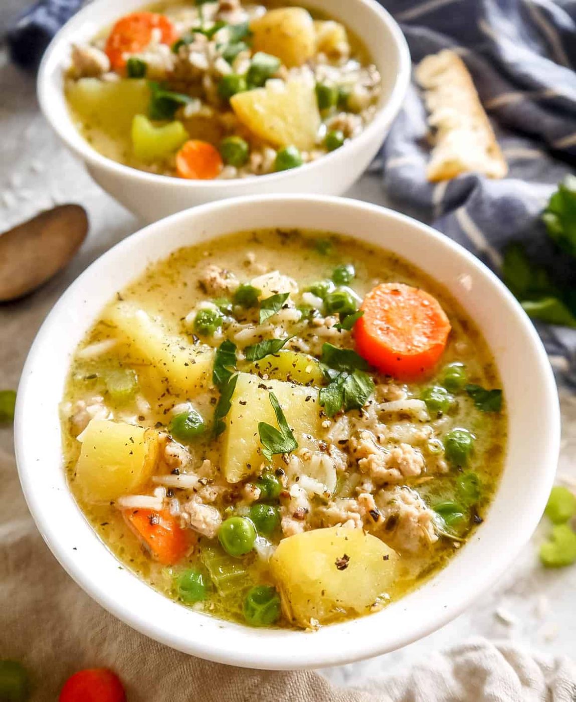 Up close photo of turkey soup with potatoes and carrots inside.
