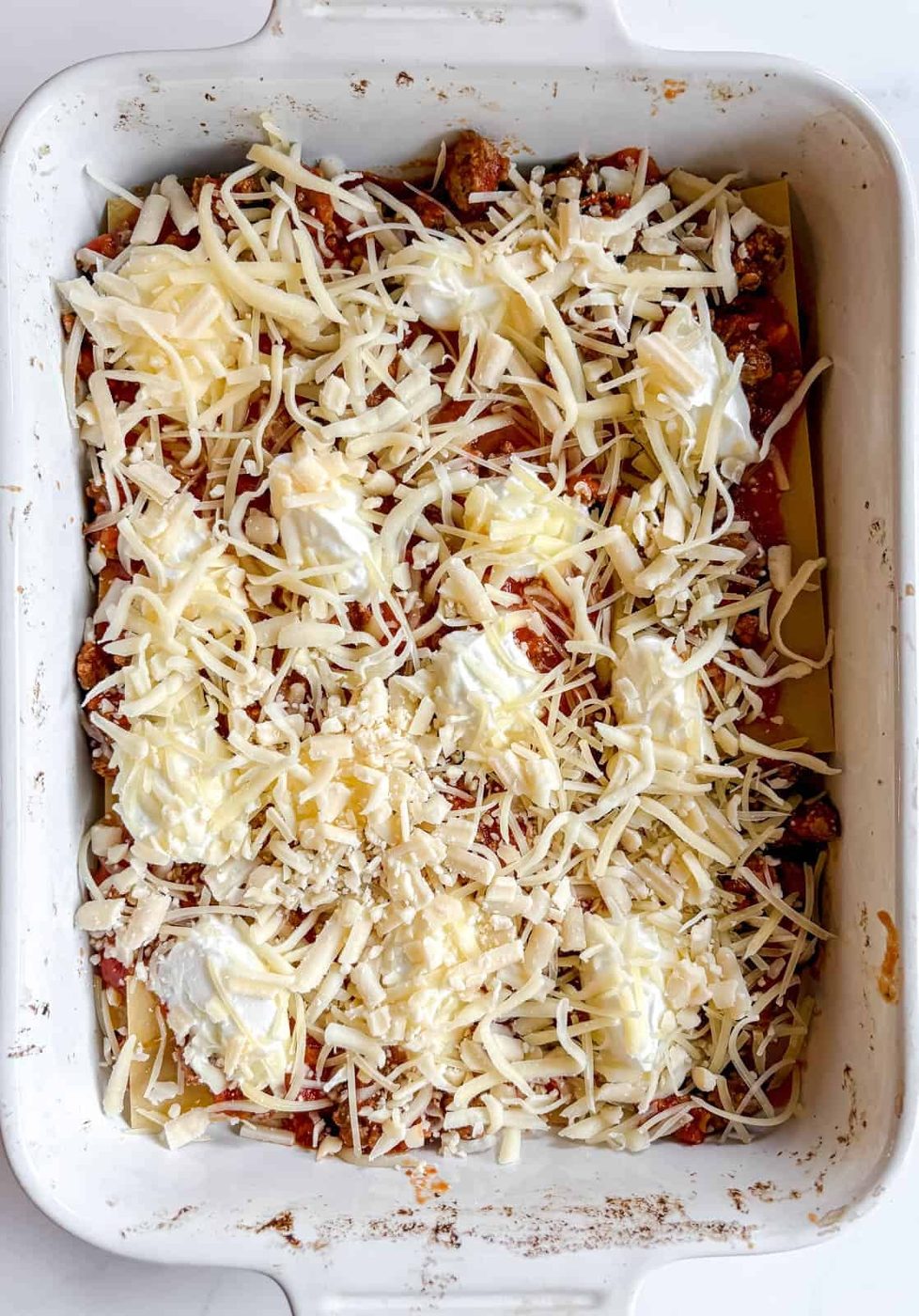 Shredded cheese added to the lasagna layer.