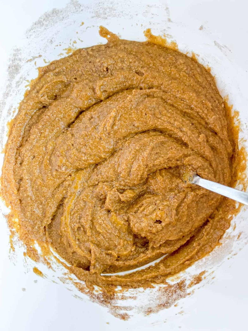 Wet and dry ingredients mixed together for pumpkin muffins.