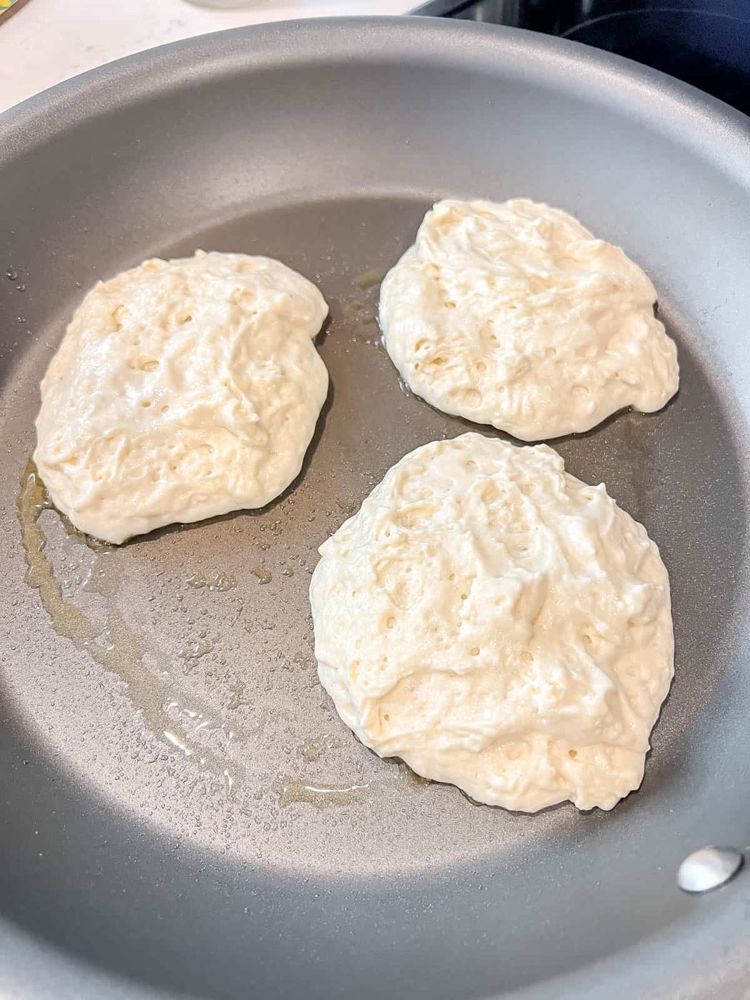 Greek yogurt pancakes before flipping on a pan.