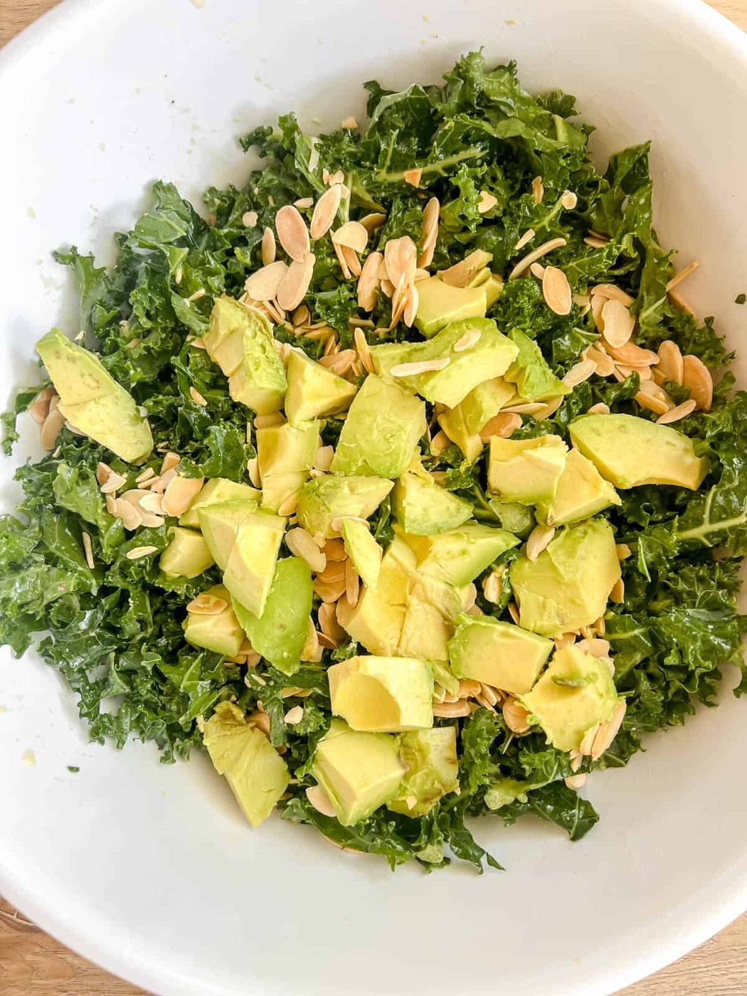 Avocado and almonds added to lemon kale salad.