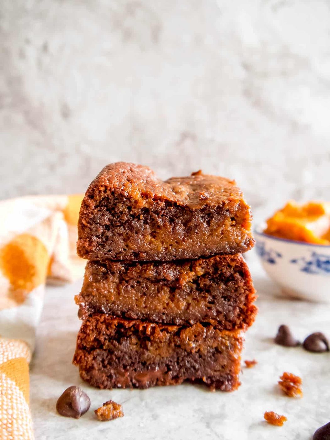 Paleo pumpkin brownies stacked on top of each other.