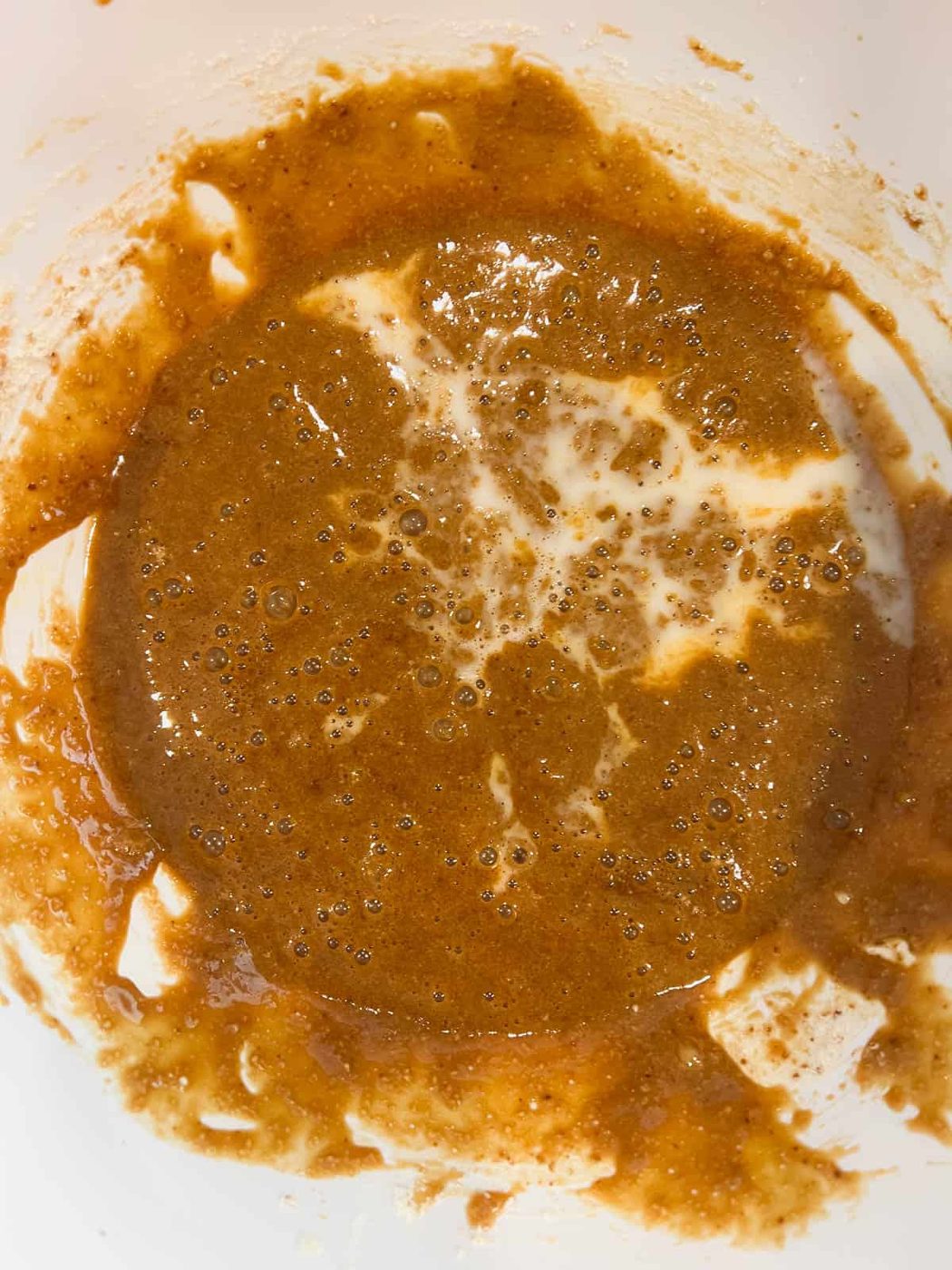 Adding almond milk to the batter.
