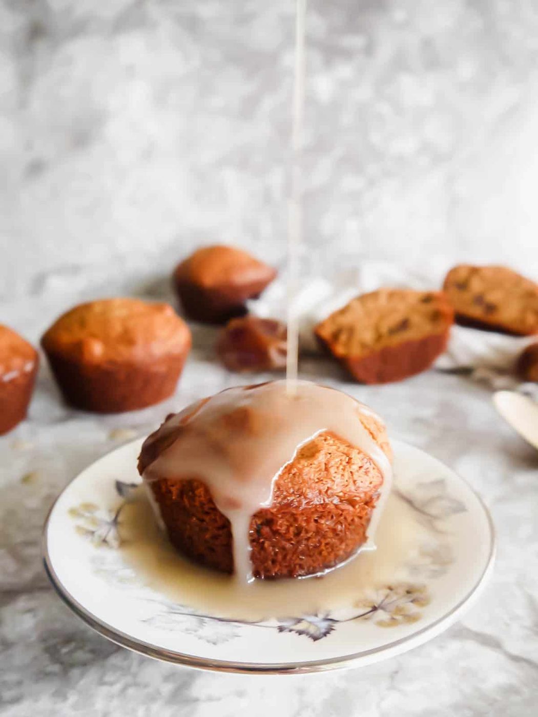 Caramel sauce being poured on top of a Paleo sticky toffee pudding dessert muffin.