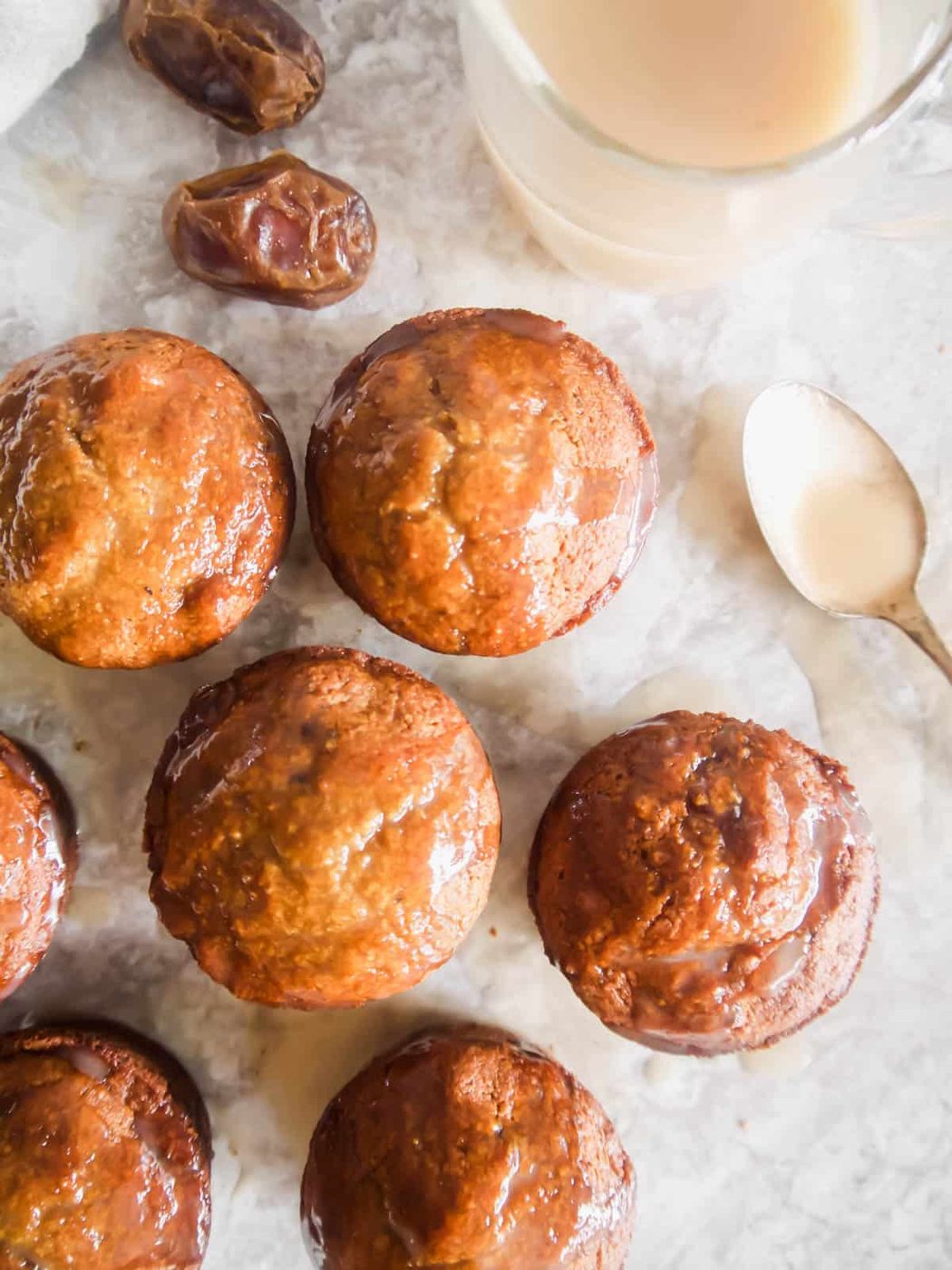 Gluten-Free Paleo Sticky Toffee Pudding Muffins on a table after having sauce poured on top of them.
