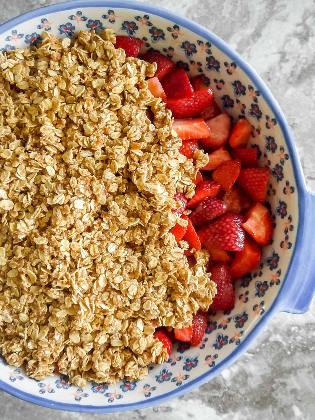Crisp topping on top of strawberries to make strawberry crisp.