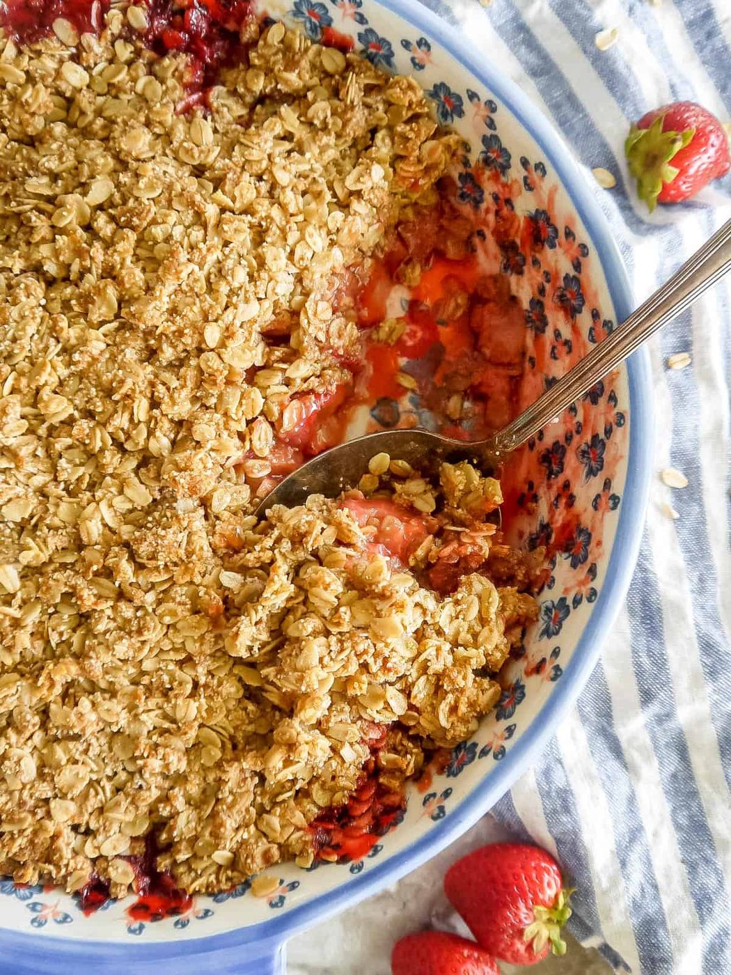 A large spoon scooping out some strawberry crisp.