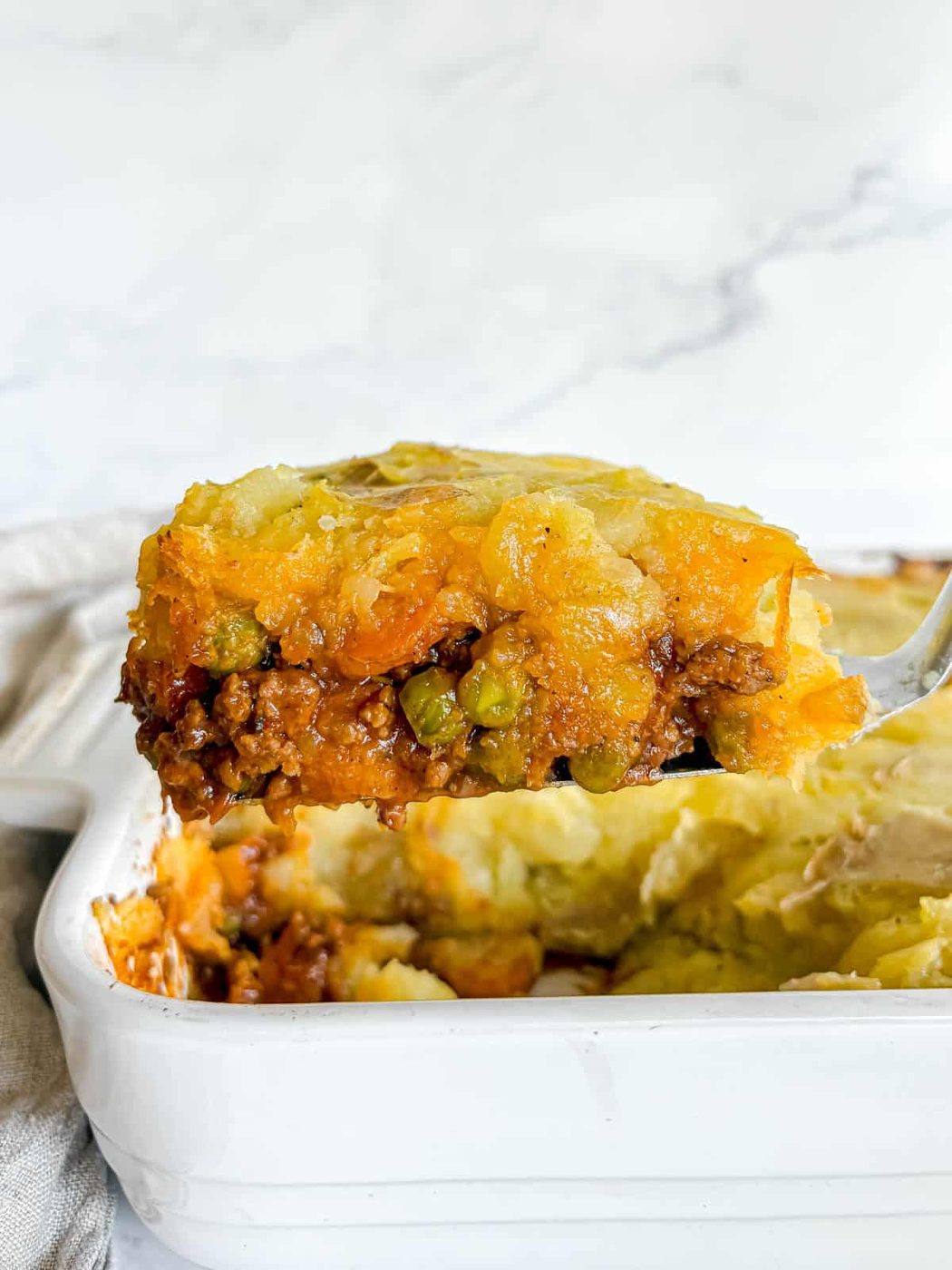 Lifting a slice of beef shepherd's pie out of a pan.