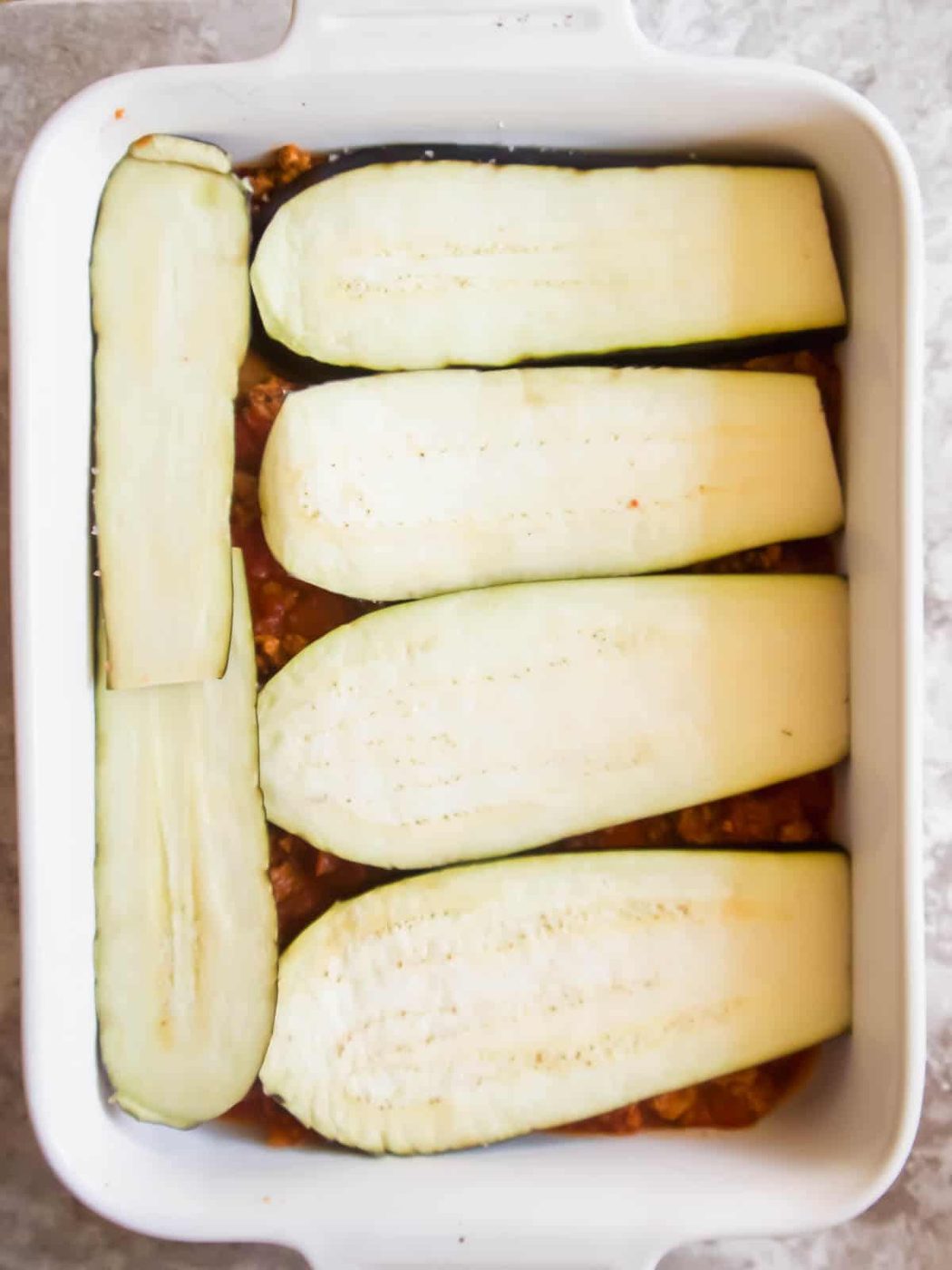 Eggplant layer added to the pan.