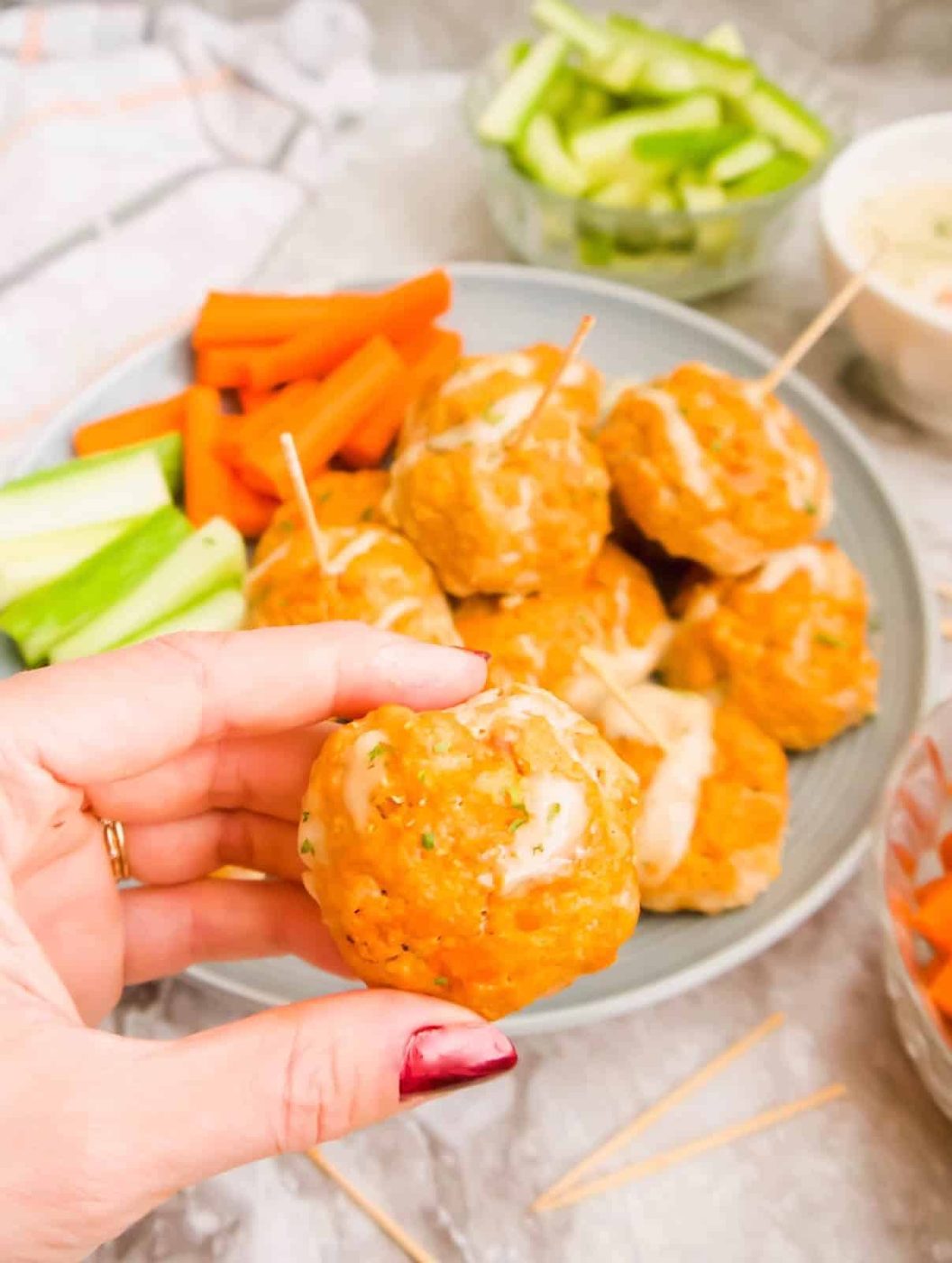 A hand holding a lighter buffalo turkey meatball.