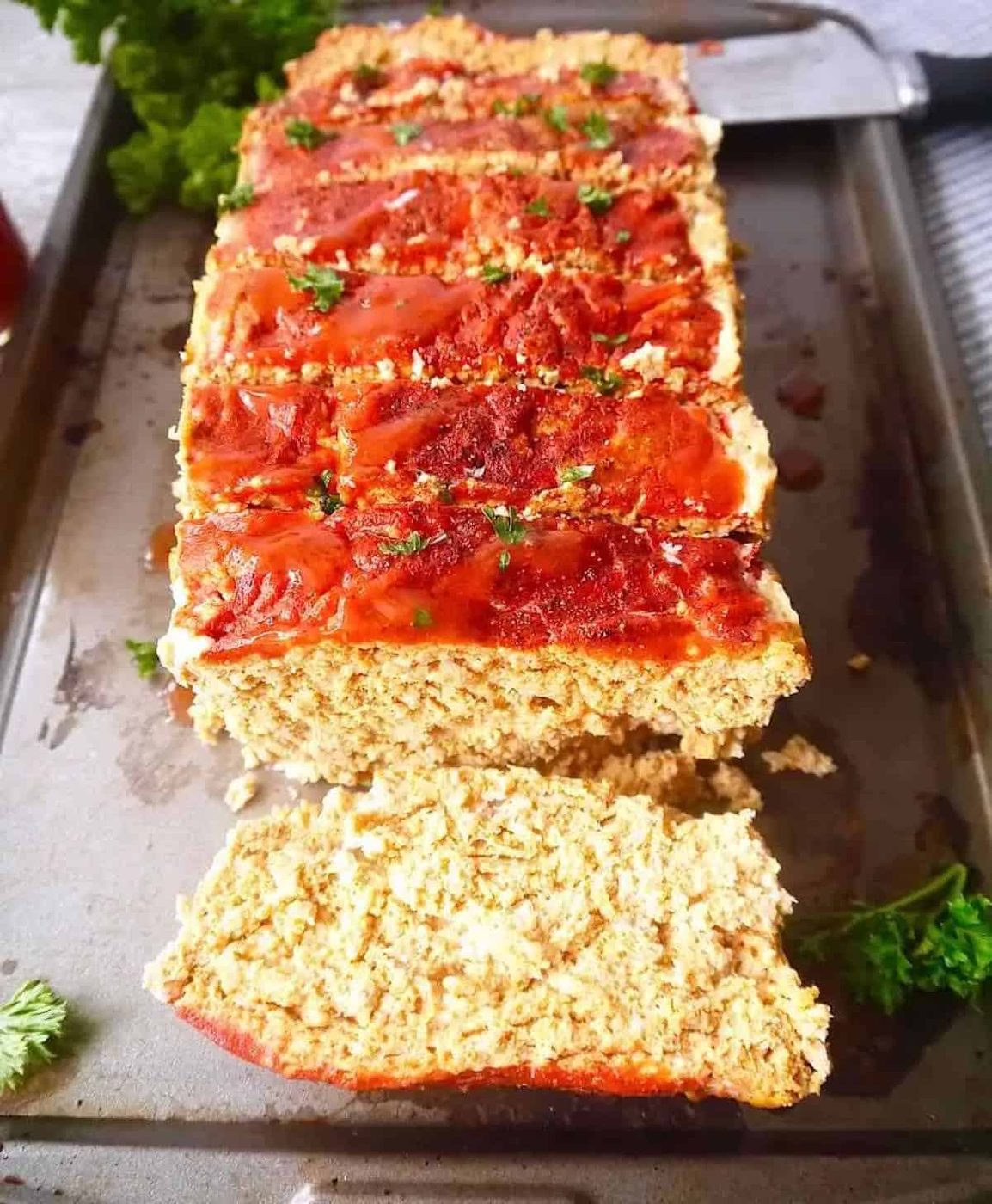Paleo turkey meatloaf with hot sauce seasoning on a pan.
