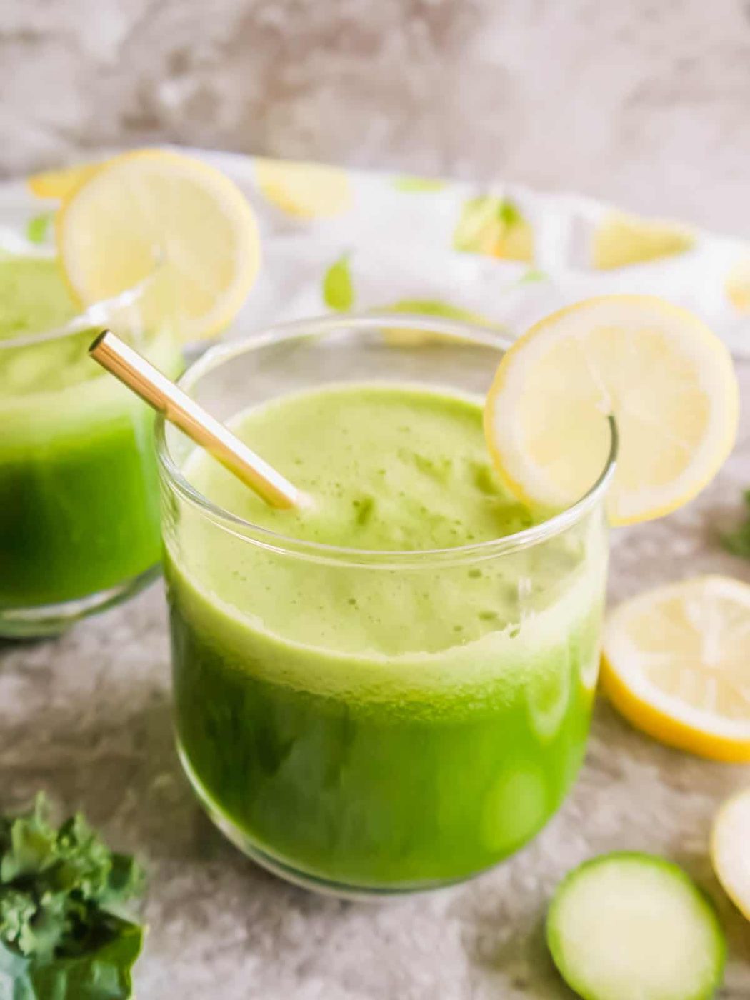 Lighter lemonade in a glass with lemon on the rim.