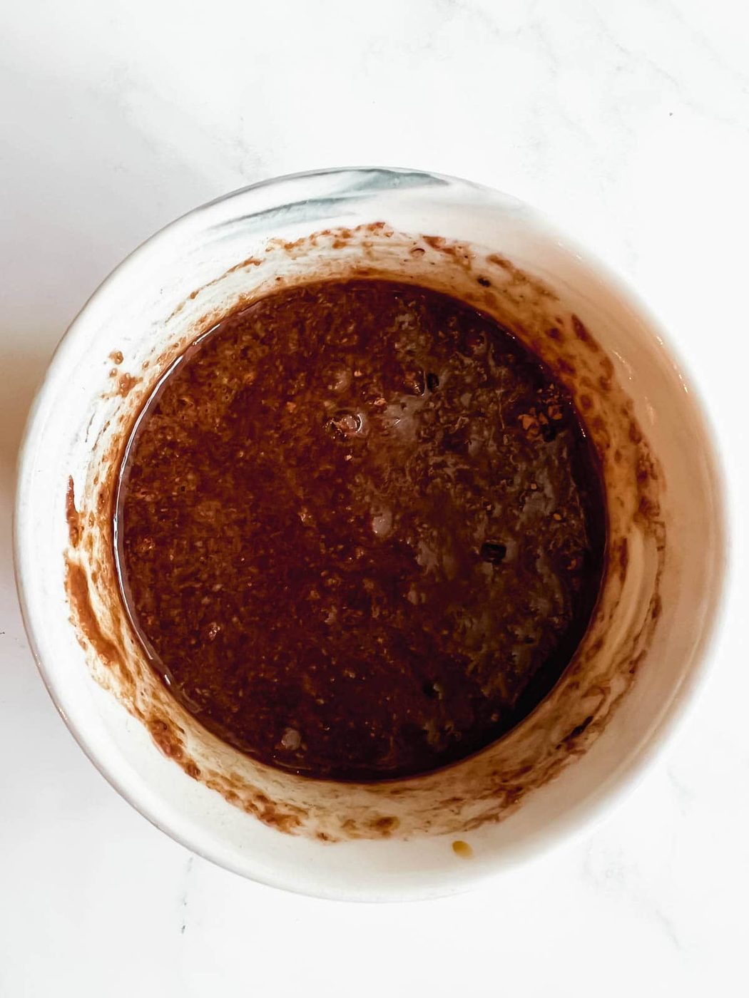 Wet microwave mug brownie ingredients in a ramekin.