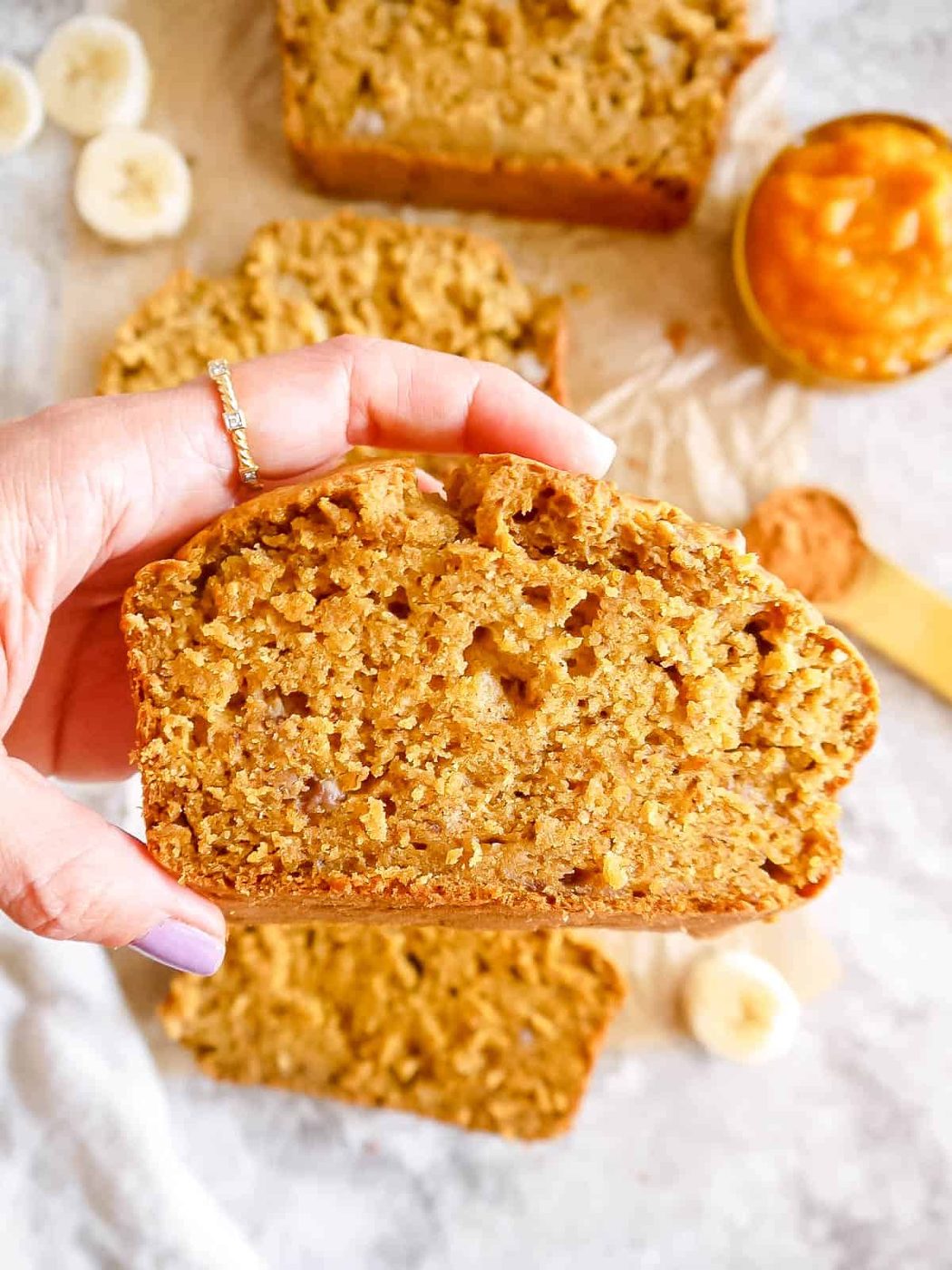 Slice of banana pumpkin bread in hands.