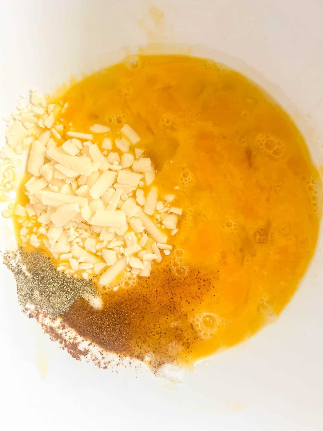 Cheese and spices added to the eggs.