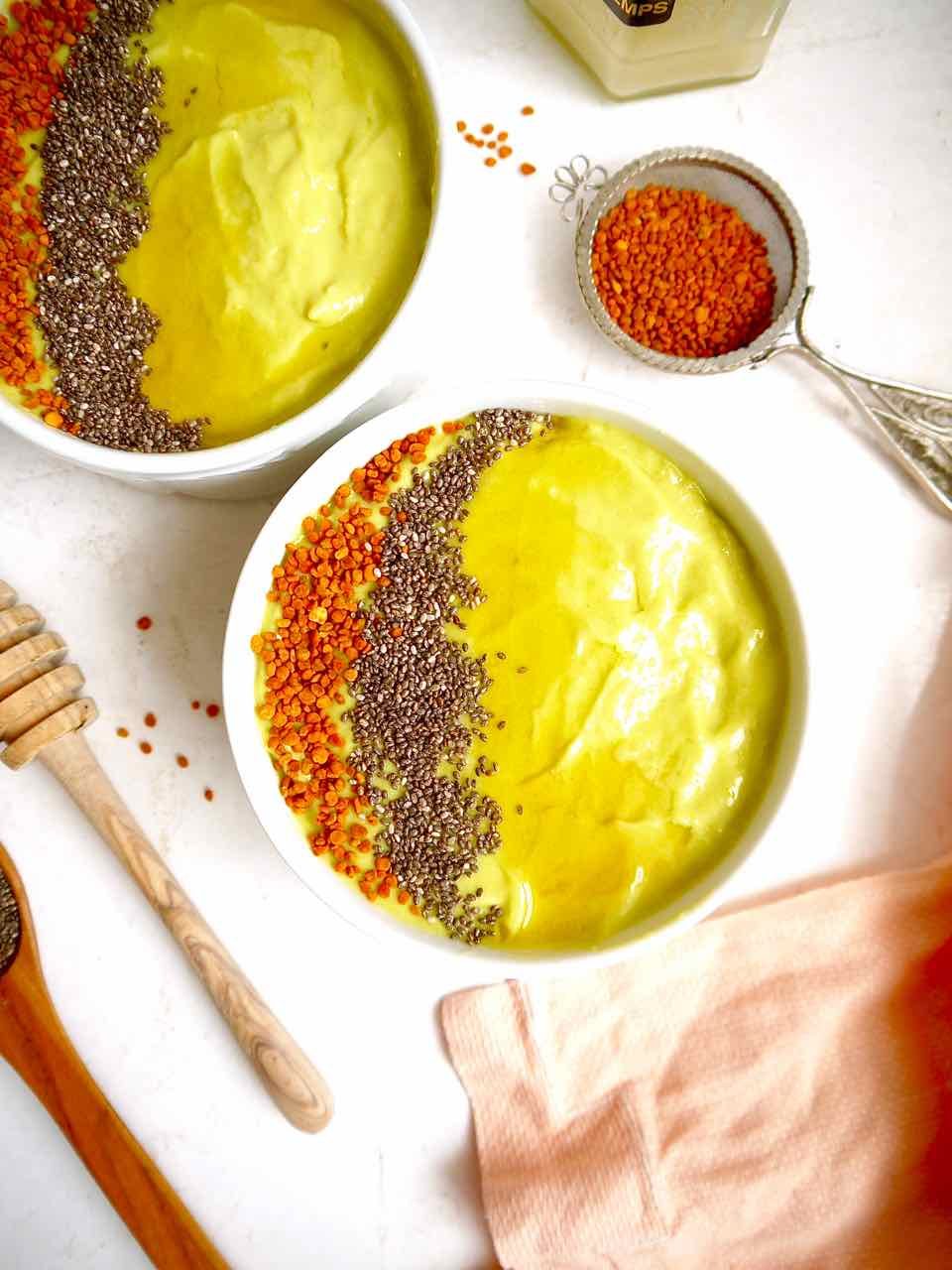 Avocado Mango Smoothie in a bowl with honey on top.