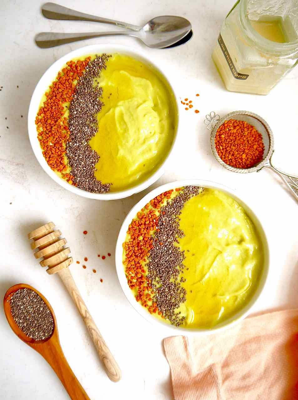 Two Avocado Mango Smoothie bowls with bee pollen on top.