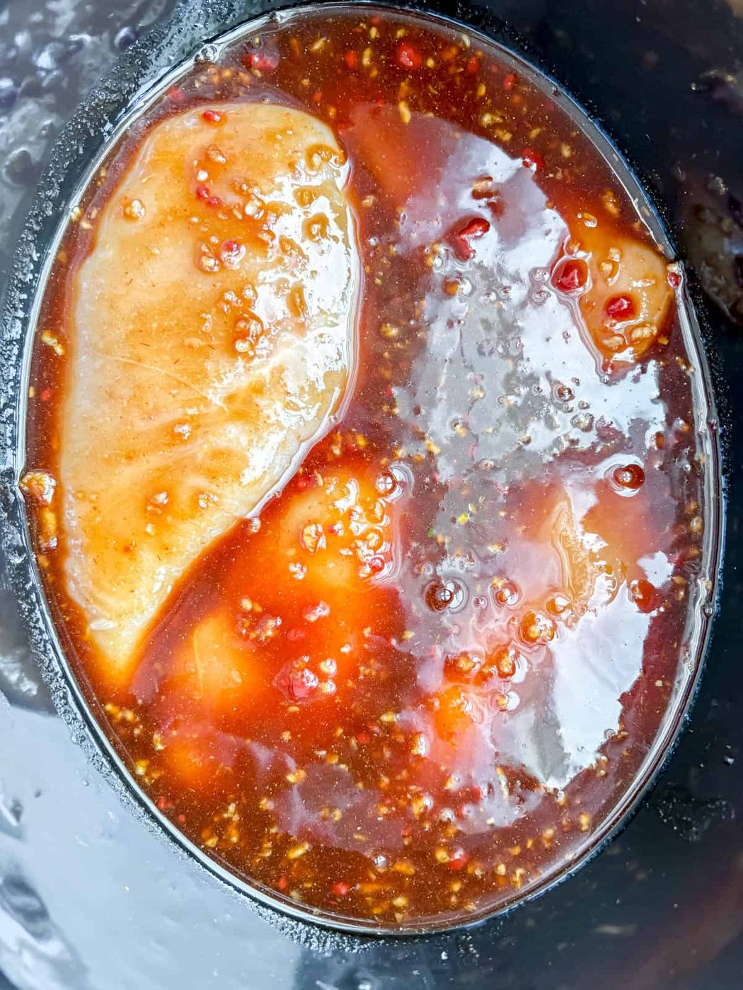 Honey garlic chicken in slow cooker before cooking.